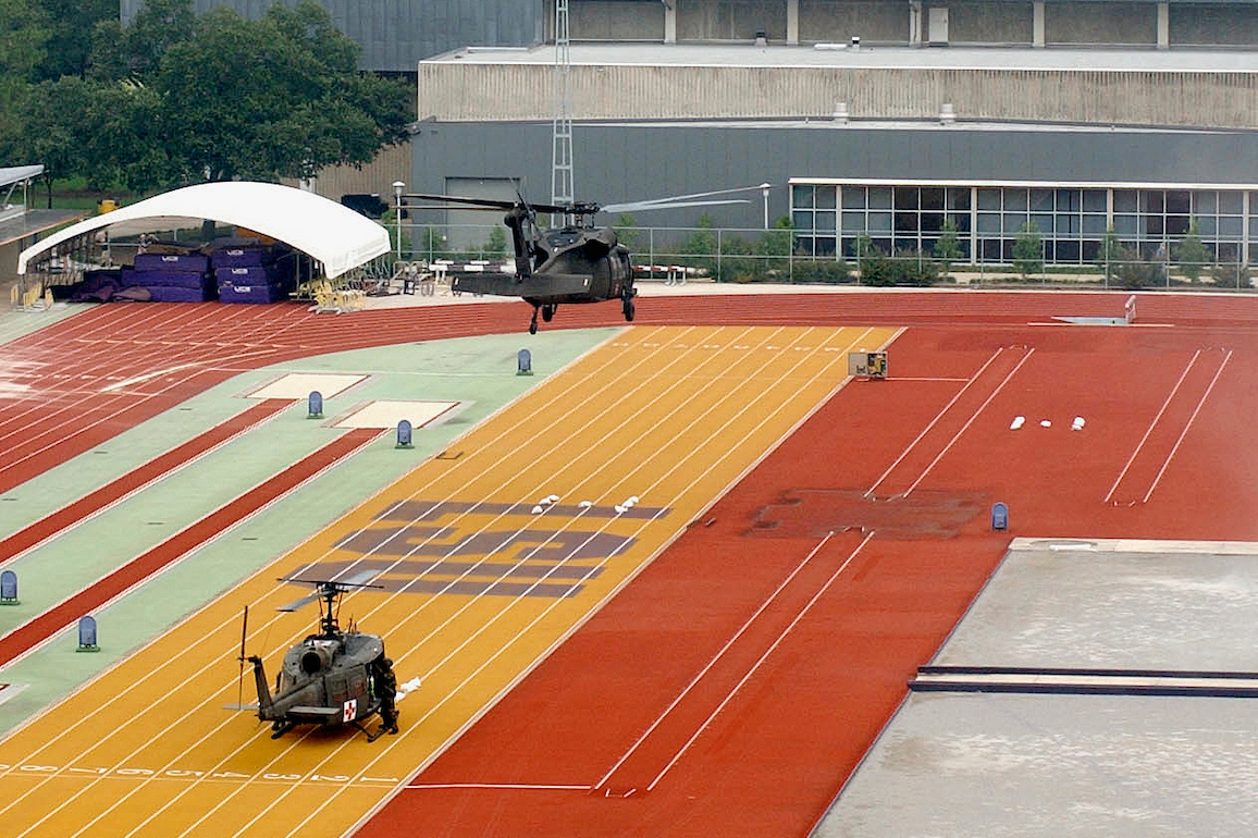 A helicopter lifts off and a second prepares to lift off from the Bernie Moore Track Stadium on the LSU campus.
