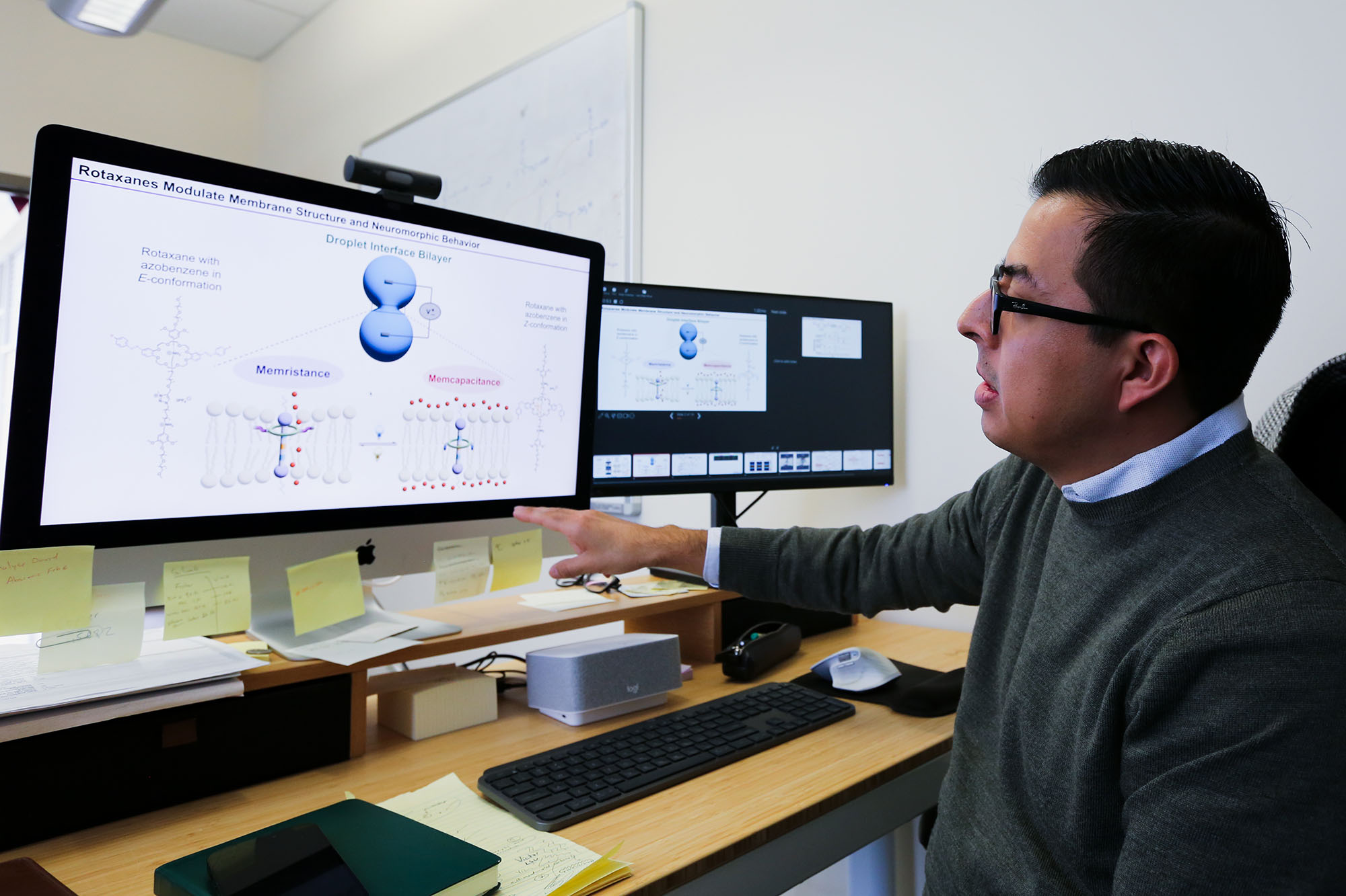 Víctor García-López points out a research detail on a computer screen