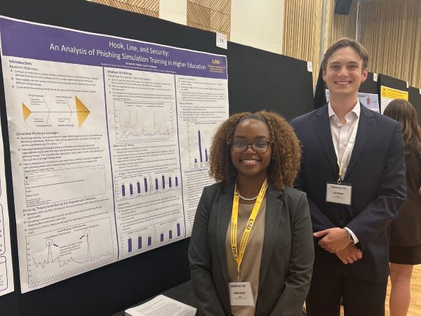 Briana Dalton and Jack Urbanek stand in front of their research poster. 