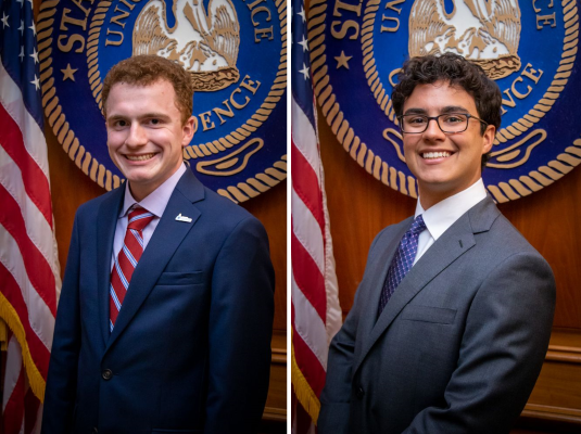 Head shots of two men in suits. Both are in front a the Louisiana State seal with the American flag in the background. 